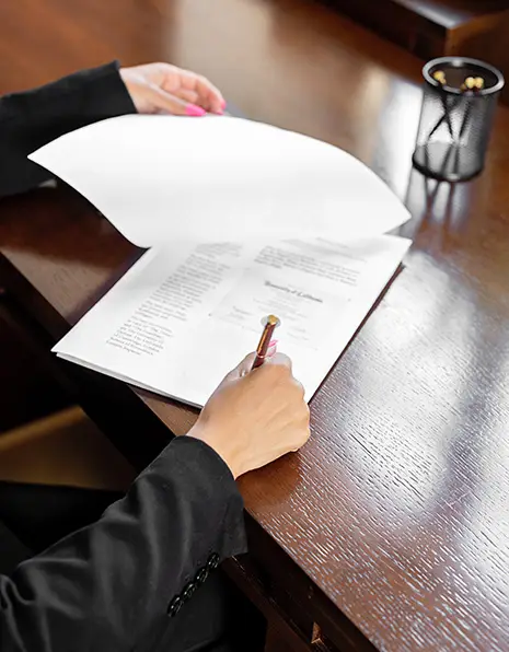 A woman is writing on a piece of paper.